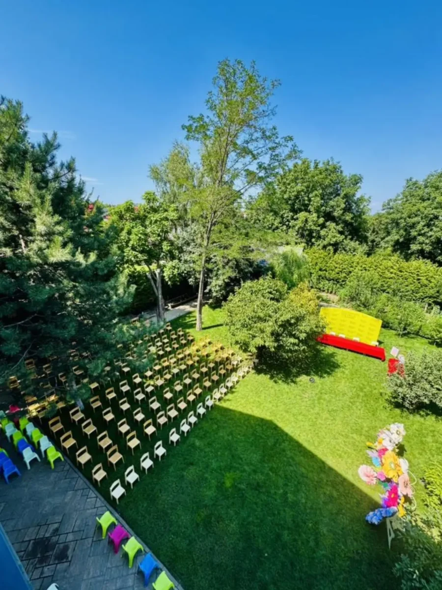 Curtea Grădiniței Amicus Junior din Iași văzută de sus, cu scaunele aranjate pentru un eveniment