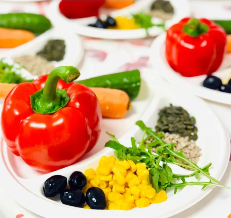 Farfurie cu ardei umplut, legume proaspete, măsline și porumb, din meniul ovo-lacto-vegetarian al Grădiniței Amicus Junior din Iași